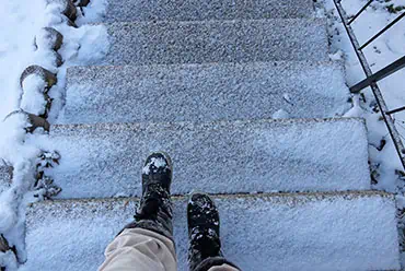 A person standing on snow-covered stairs - Fall Law